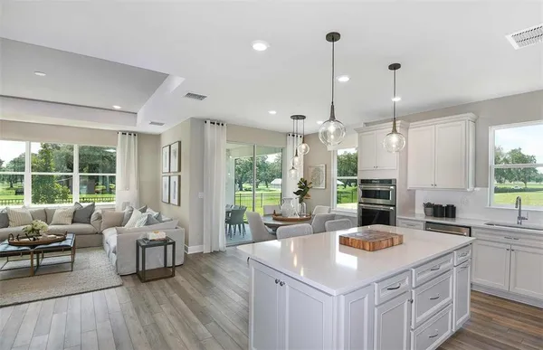 a kitchen with stainless steel appliances granite countertop a sink a stove and a wooden floors
