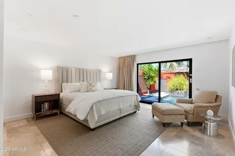 a spacious bedroom with a bed and glass window