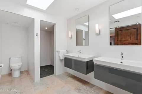 a spacious bathroom with a toilet sink and mirror