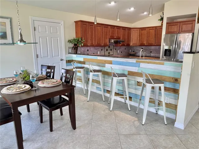 a kitchen with stainless steel appliances granite countertop a refrigerator and a stove top oven