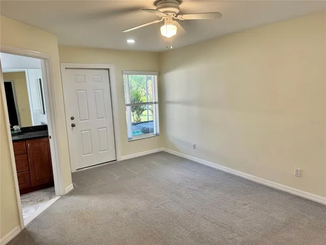 a view of a workspace with furniture and a ceiling fan