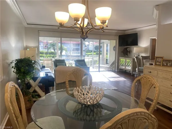 a living room with furniture chandelier and a large window