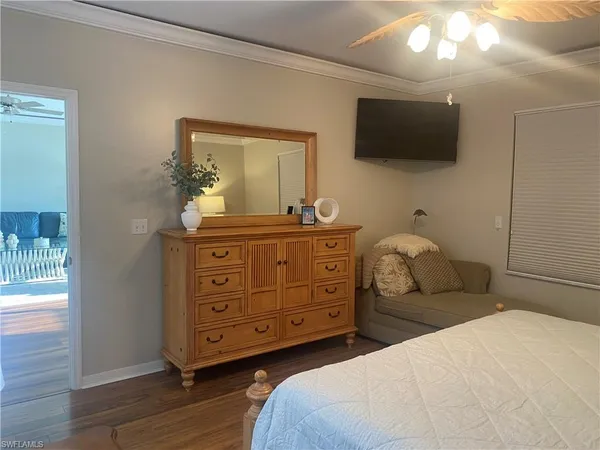 a bedroom with a bed and a flat tv screen on dresser