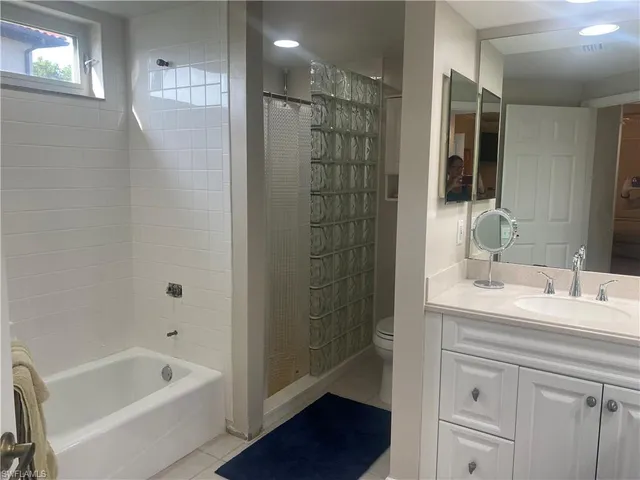 a bathroom with a tub a sink and mirrors
