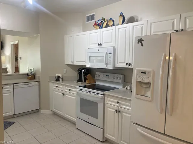 a white kitchen with cabinets stainless steel appliances and a sink