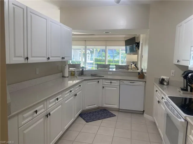 a kitchen with a sink window and cabinets