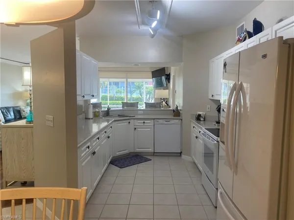 a kitchen with a refrigerator sink and cabinets