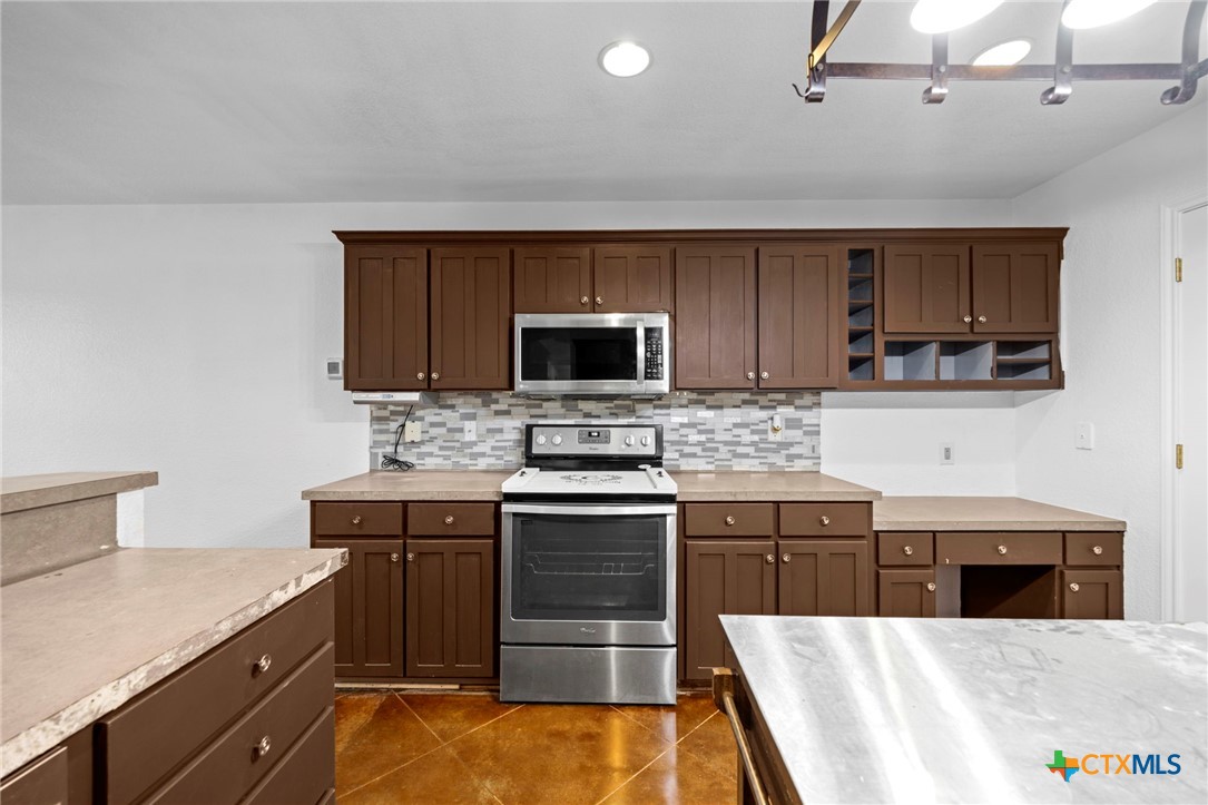 601 7 Ranch Road Salado, TX 76571 - Photo 27 of 44 a kitchen with stainless steel appliances a stove sink microwave and cabinets