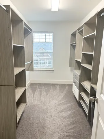 a view of walk in closet with empty racks