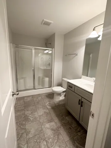 a bathroom with a granite countertop sink mirror and shower