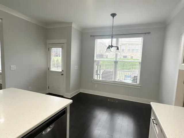 a view of a kitchen with wooden floor and a window