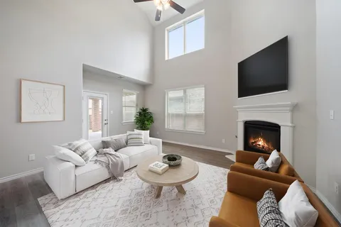 a living room with furniture a flat screen tv and a fireplace