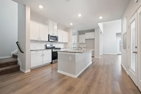 a kitchen with white cabinets and white appliances