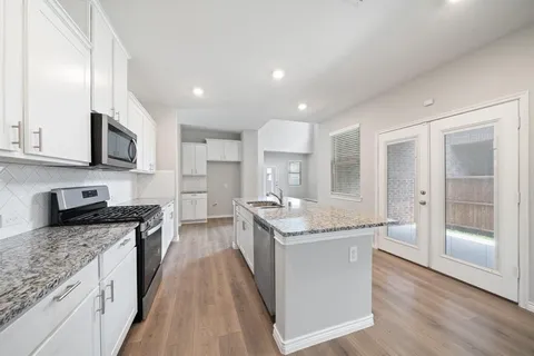 a kitchen with stainless steel appliances granite countertop wooden cabinets and a granite counter tops