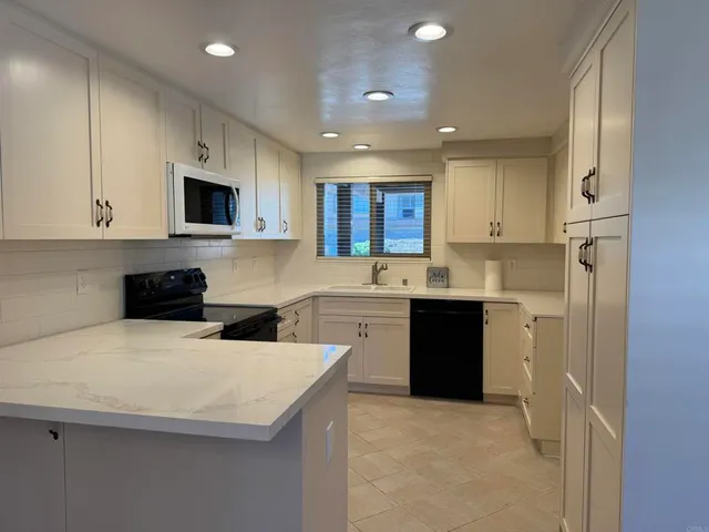 a kitchen with a sink a stove a refrigerator a microwave and cabinets