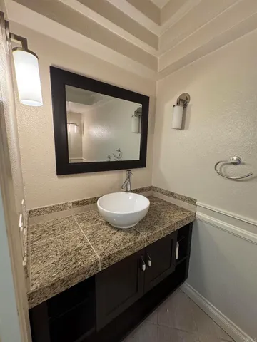 a bathroom with a granite countertop sink and a mirror