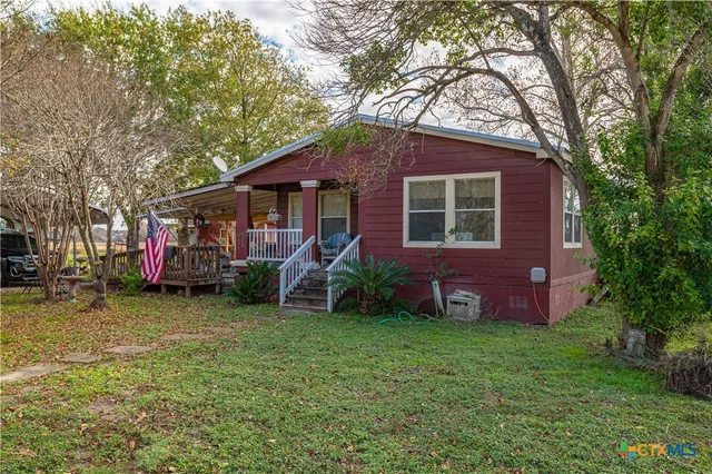 a view of a house with a yard and a tree