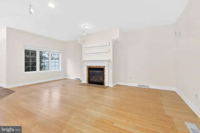 a view of an empty room with a window and fireplace