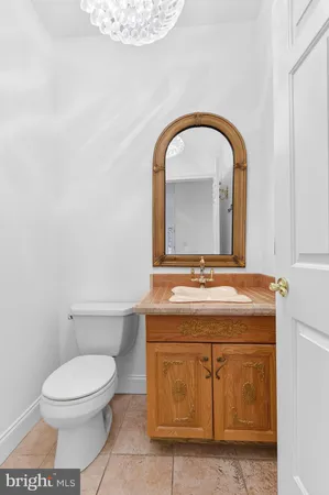 a bathroom with a granite countertop toilet a sink and mirror