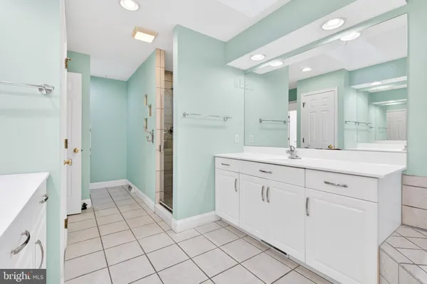 a spacious bathroom with a granite countertop sink mirror and a