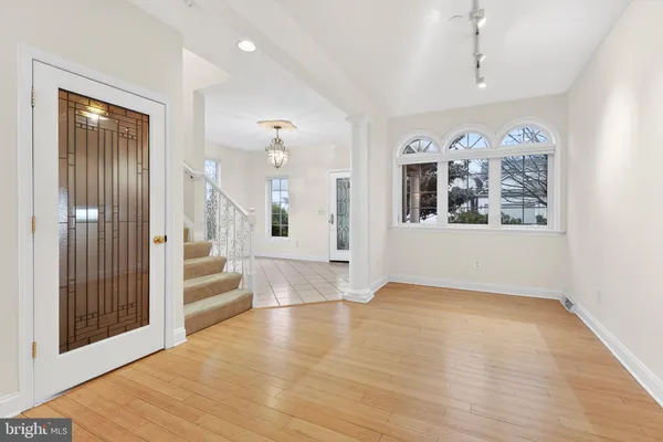 a view of a big room with wooden floor and windows