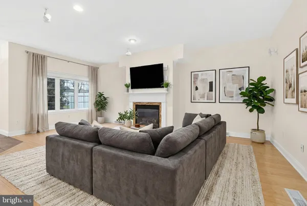 a living room with furniture a flat screen tv and a fireplace