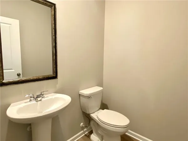 a bathroom with a sink a toilet and mirror