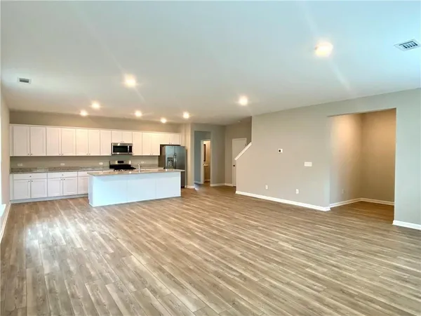 a view of kitchen with kitchen island wooden floor and center island