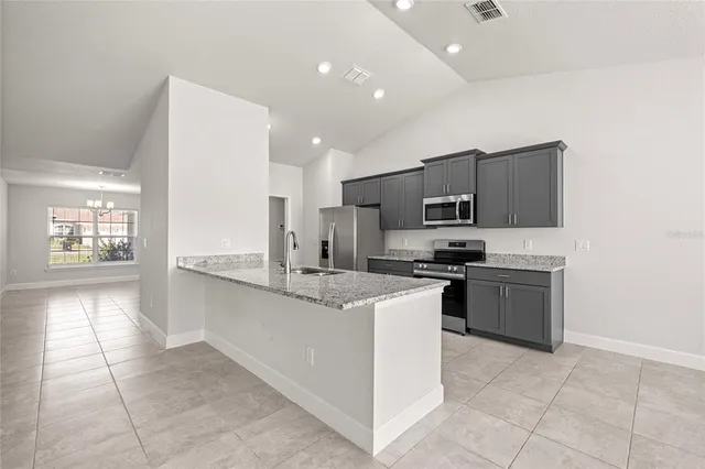 a large kitchen with a stove a sink and a refrigerator