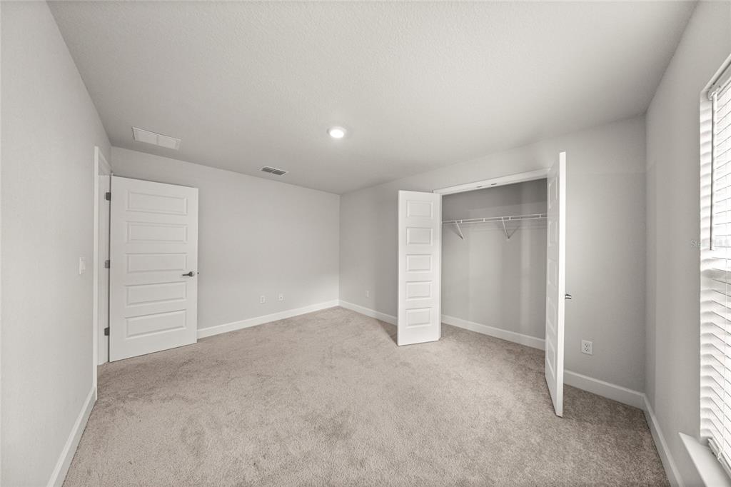 4984 Southwest 91st Place Ocala, FL 34476 - Photo 27 of 42 an empty room with window in back and closet area