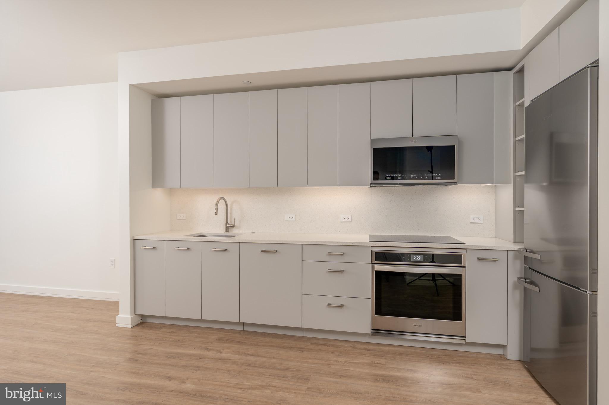 1630 Columbia Road Northwest, Unit 307 Washington, DC 20009 - Photo 2 of 21 a kitchen with stainless steel appliances a stove a sink and a microwave