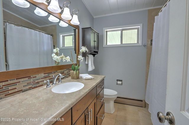 a bathroom with a granite countertop sink toilet and a mirror
