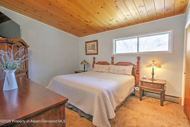 a bedroom with a bed and a table with potted plants