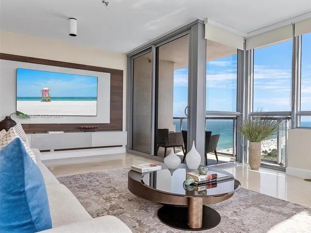 a living room with fireplace furniture and a rug