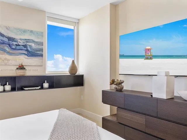 a large bed sitting in a room next to a lamp with kitchen view