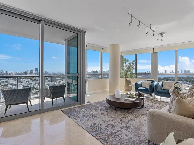 a living room with furniture kitchen view and a large window