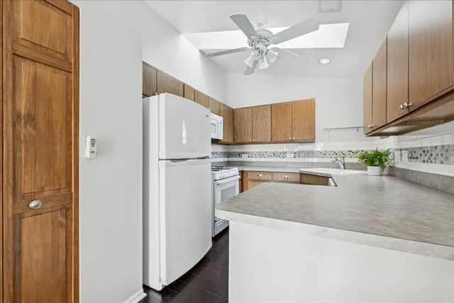 a kitchen with stainless steel appliances granite countertop a refrigerator a stove and a sink with wooden floor