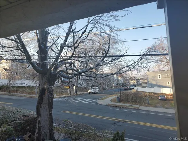 a view of a yard and car parked on the road
