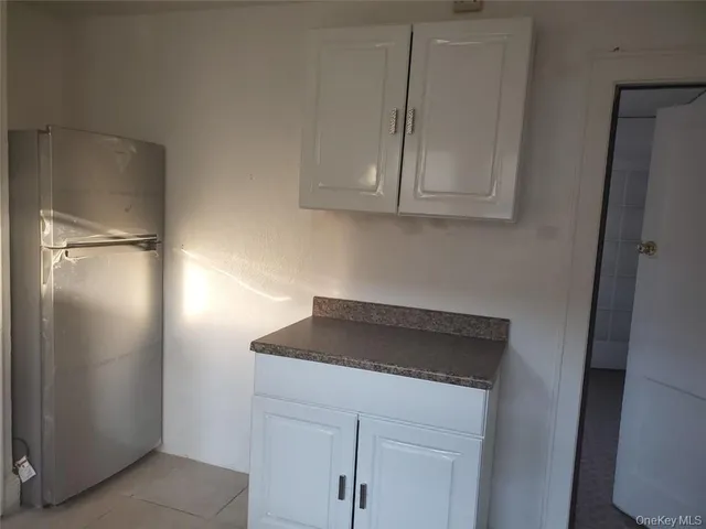 a kitchen with cabinets and a refrigerator