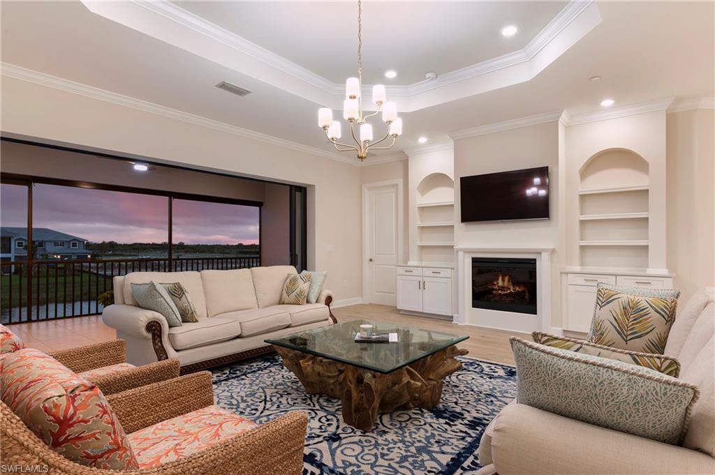 15328 Lucerna Street, Unit 202 Naples, FL 34114 - Photo 4 of 32 a living room with furniture a fireplace and a flat screen tv