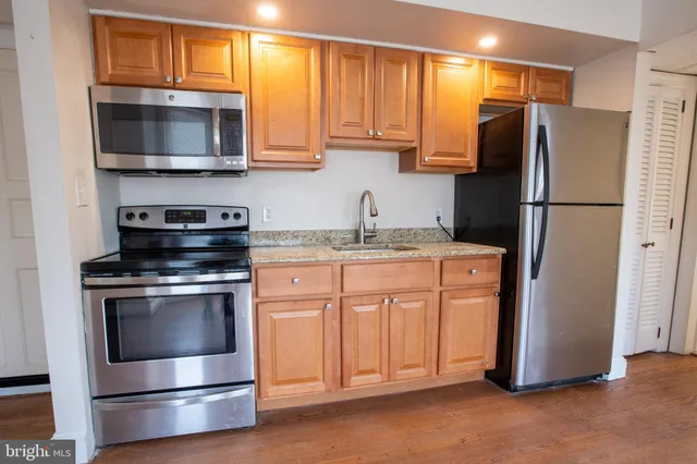 a kitchen with stainless steel appliances granite countertop a refrigerator stove and microwave