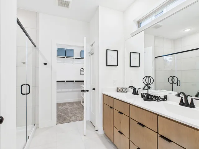 a bathroom with a double vanity sink mirror and shower