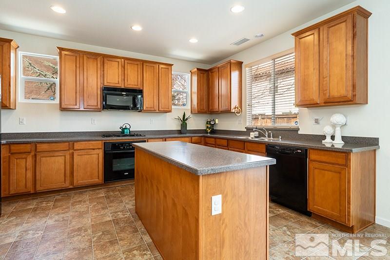 475 Stradella Court Reno, NV 89521 - Photo 5 of 22 a kitchen with stainless steel appliances granite countertop a sink stove microwave and refrigerator