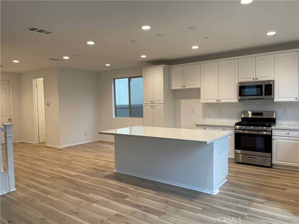 349 Lilly Street Rialto, CA 92376 - Photo 4 of 25 a kitchen with stainless steel appliances granite countertop a stove a sink and a refrigerator