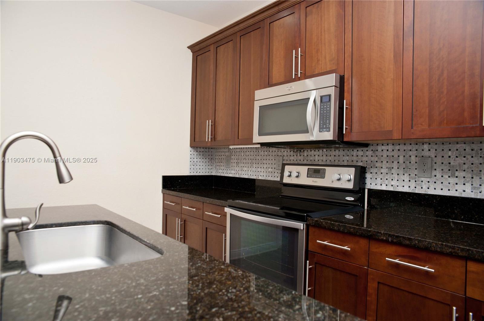 14620 Southwest 15th Street Pembroke Pines, FL 33027 - Photo 20 of 59 a kitchen with granite countertop a stove sink and cabinets