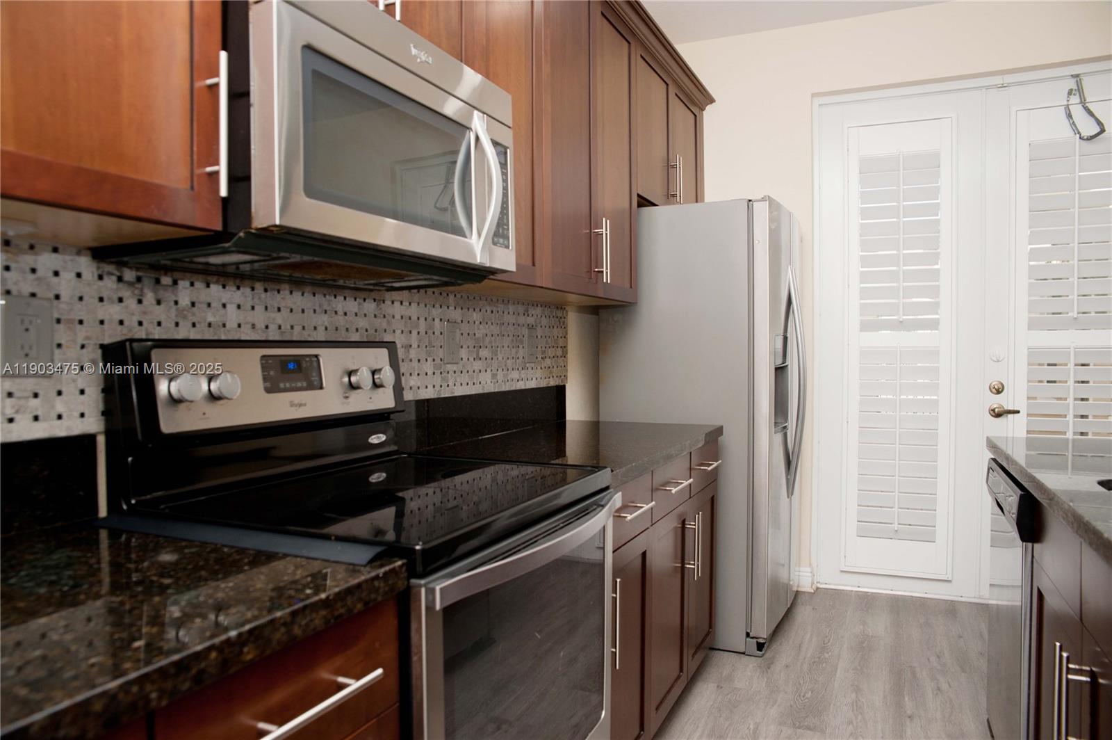14620 Southwest 15th Street Pembroke Pines, FL 33027 - Photo 21 of 59 a kitchen with granite countertop a stove and a microwave