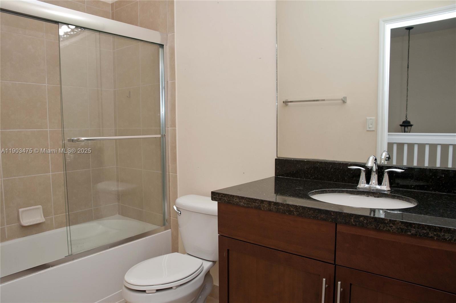 14620 Southwest 15th Street Pembroke Pines, FL 33027 - Photo 34 of 59 a bathroom with a granite countertop sink toilet a mirror and shower