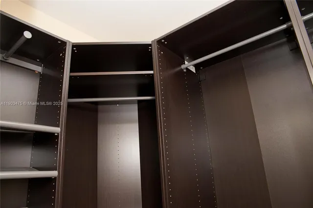 a view of walk in closet with wooden floor