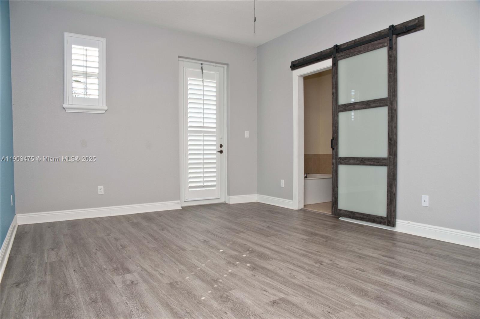 14620 Southwest 15th Street Pembroke Pines, FL 33027 - Photo 39 of 59 an empty room with wooden floor and windows
