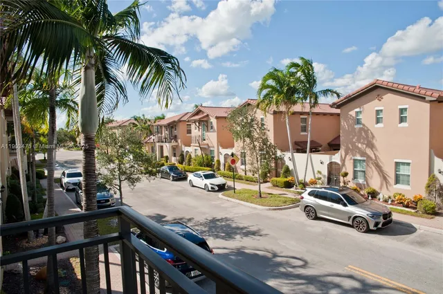 a view of a swimming pool with a lawn chairs under palm trees